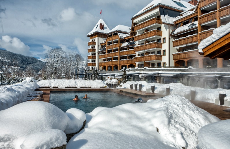 Soak up the stunning scenery from the outdoor swimming pool at The Alpina Gstaad