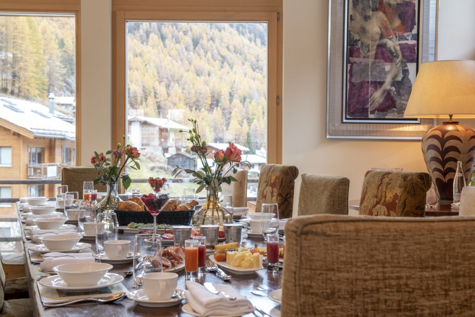 The dining table of Chalet Grace, where you will indulge in delicious gourmet dinners prepared by Michelin-trained chefs while staying in your Zermatt luxury ski chalet. 