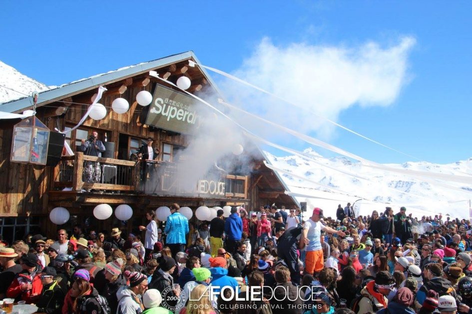 La Folie Douce Val Thorens Crowds outside La Folie Douce as a smoke cannonis set off, with blue skies behind. Famously, La Folie Douce is one of the best après-ski bars in France.