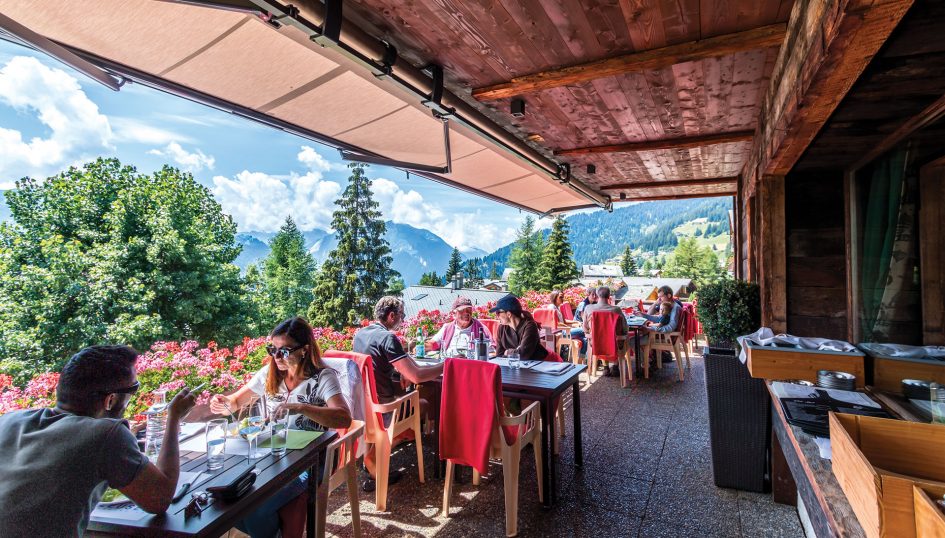 People enjoying the outdoor seating during summer in Verbier.