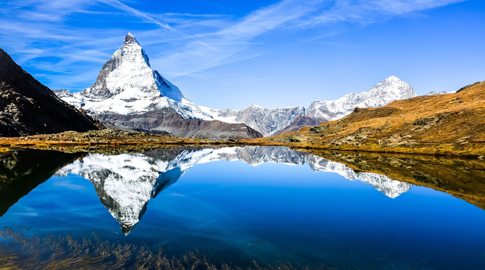 Matterhorn across a mountain lake offers a great view whilst on a holiday to the Swiss Alps. When at home, the iconic Matterhorn Mountain offers a great free Zoom background.