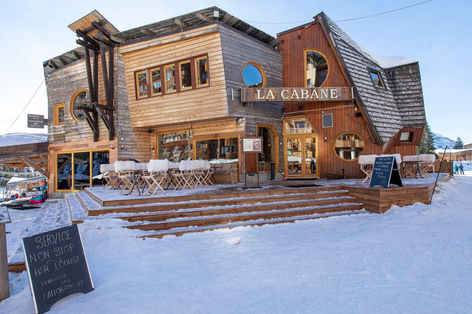 Exterior of La Cabane's wooden structure and terrace, just one of many restaurants in the Portes du Soleil