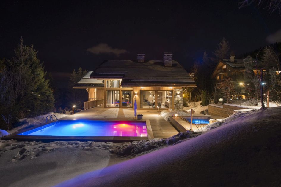 Outdoor swimming pool at night at Chalet Alpaca in Meribel