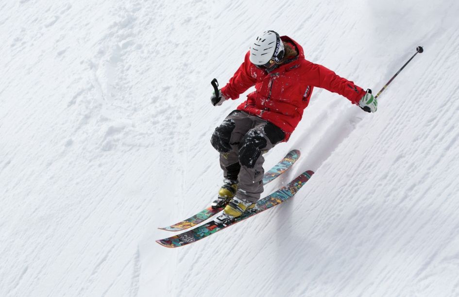 This skier has no anxiety when skiing at all as he glides through the powder on the back tips of his skis.