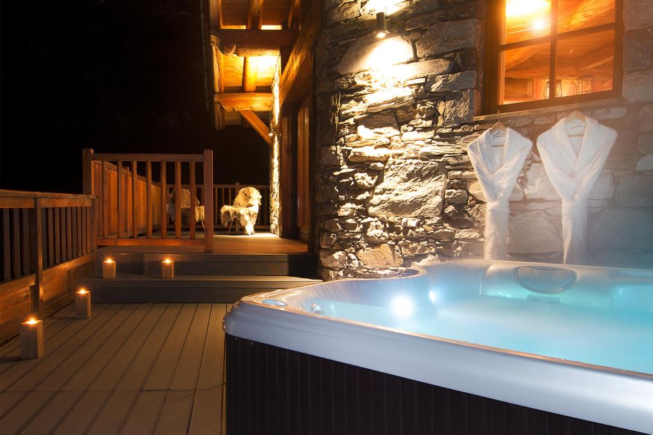 The hot tub and balcony of Chalet Arosa in Val d'Isère at nighttime.