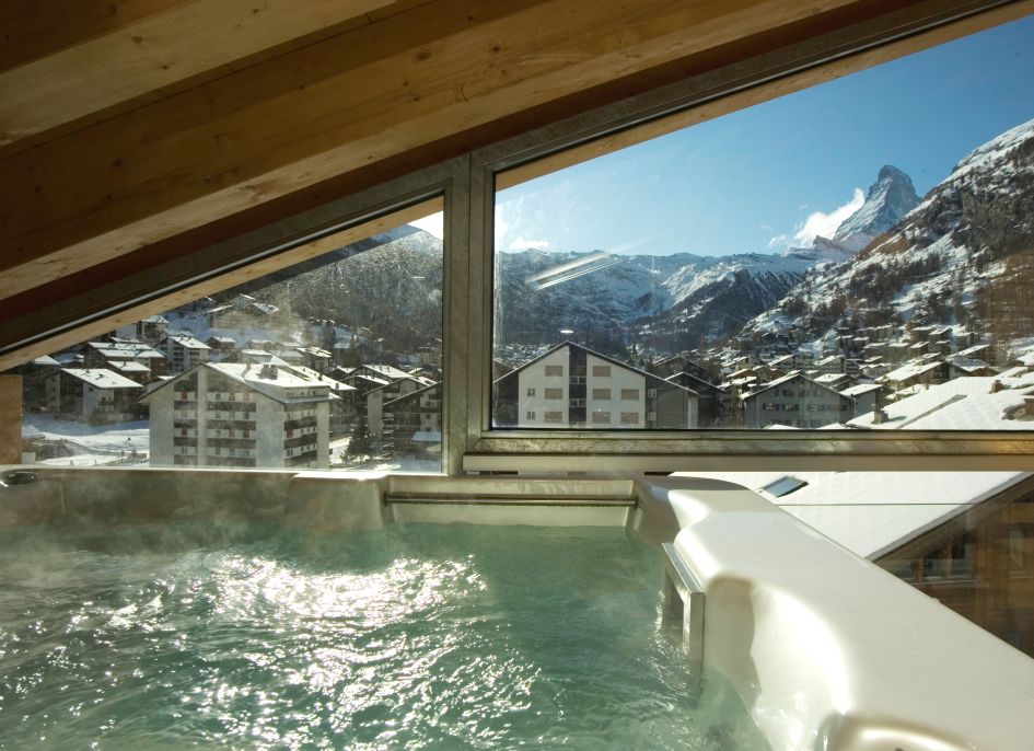 The indoor hot tub and Matterhorn views from the luxury penthouse apartment of Zermatt Lodge.