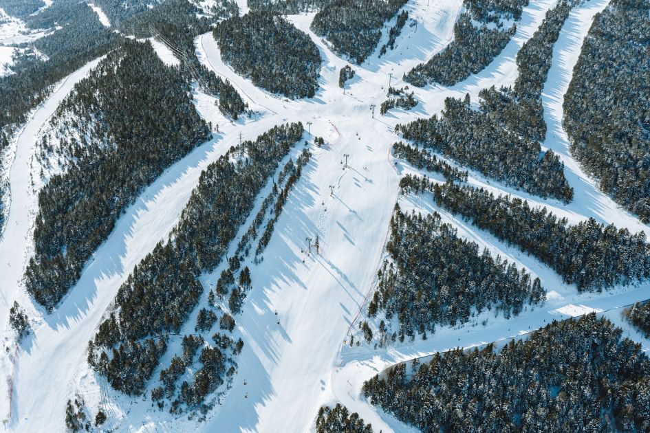 Early season skiing is one of the positives of Soldeu, Andorra, the slopes of which are seen here interspersed through the mountain forest in an aerial shot.