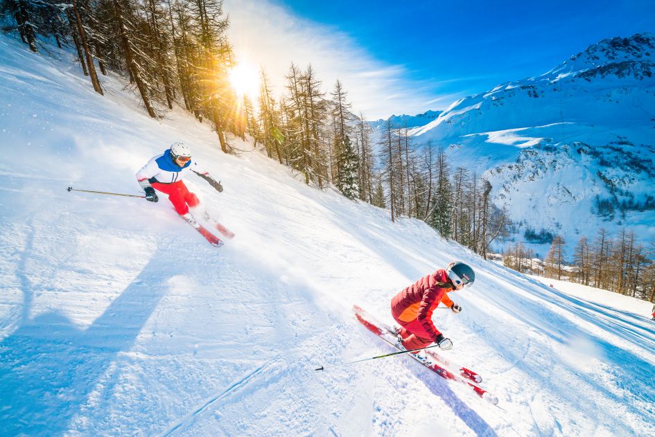 Skiing in Val d'Isère. Credit: Office du Tourisme Val d'Isère. Two skiers in Val d'Isère, one of several on our list of best resorts for early season skiing.
