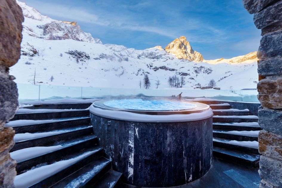 Outdoor hot tub at Chalet Fenice with heated steps leading up to it and a beautiful view of Monte Cervino in the sunlight 