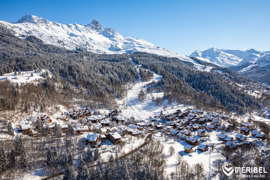 Meribel ski resort featuring snow covered chalets and buildings in the valley and towering mountain peaks in the background