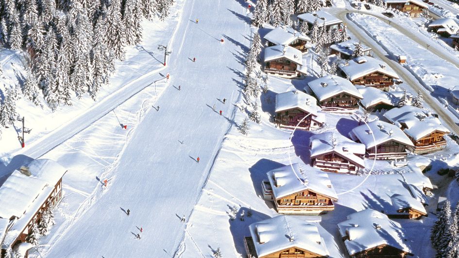 Skiers coming down the Bellecôte piste, a green run in Courchevel 1850, with the ski in ski out Chalet Le Namaste circled on the right.