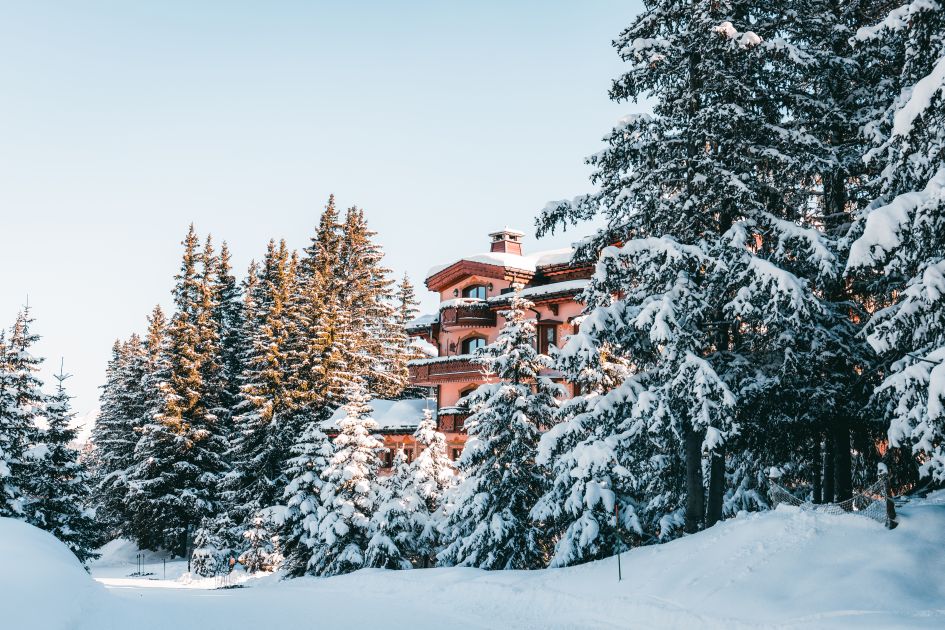 Hotel Les Airelles Courchevel, glimpsed through the trees along the green Jardin Alpin run, a ski in ski out piste in Courchevel.