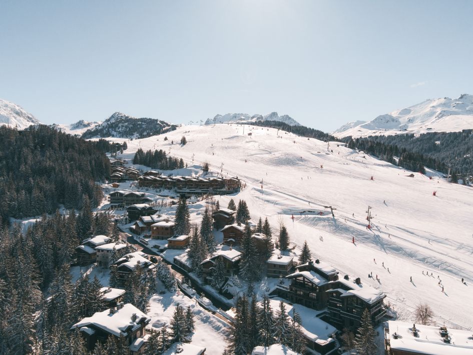 An aerial view of the green Belvédère slope, a ski in ski out piste in Courchevel Moriond. 