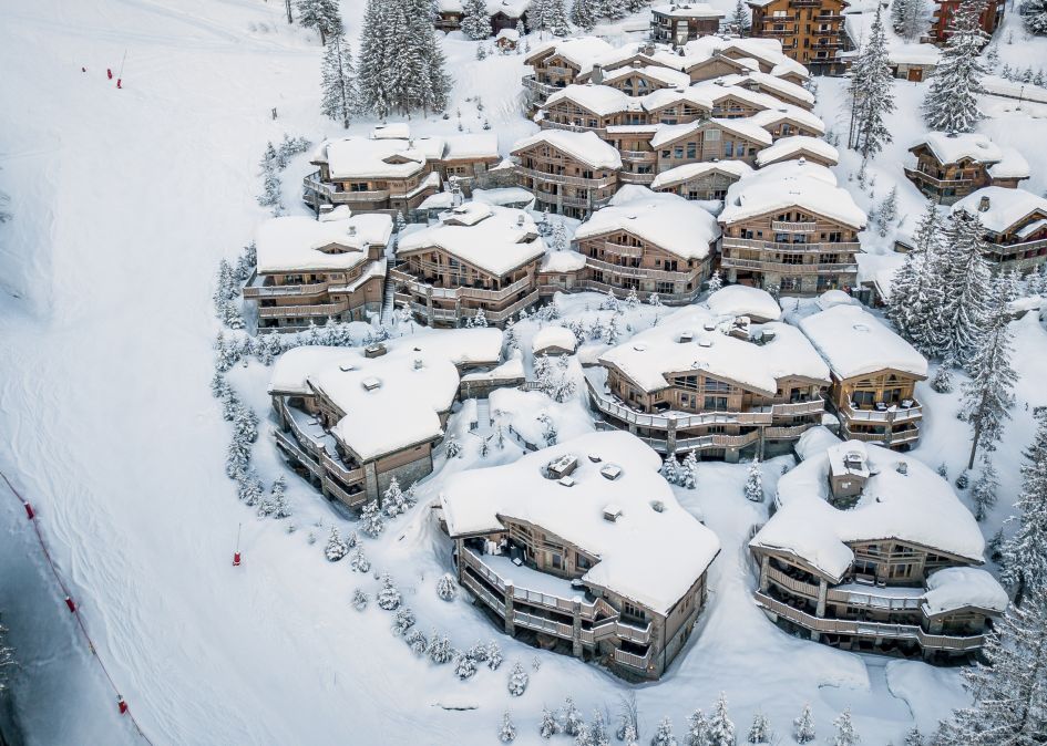 Hotel Le K2 Palace and its collection of ski in ski out chalets in Courchevel 1850 alongside the blue Cospillot piste.