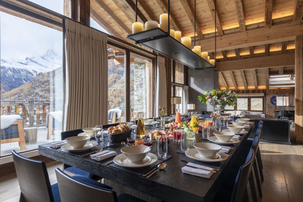 The stunning dining table of Chalet Les Anges. This luxury catered ski chalet in Zermatt has been laid beautifully by the service team, so that the guests can eat with a view of the mountains.