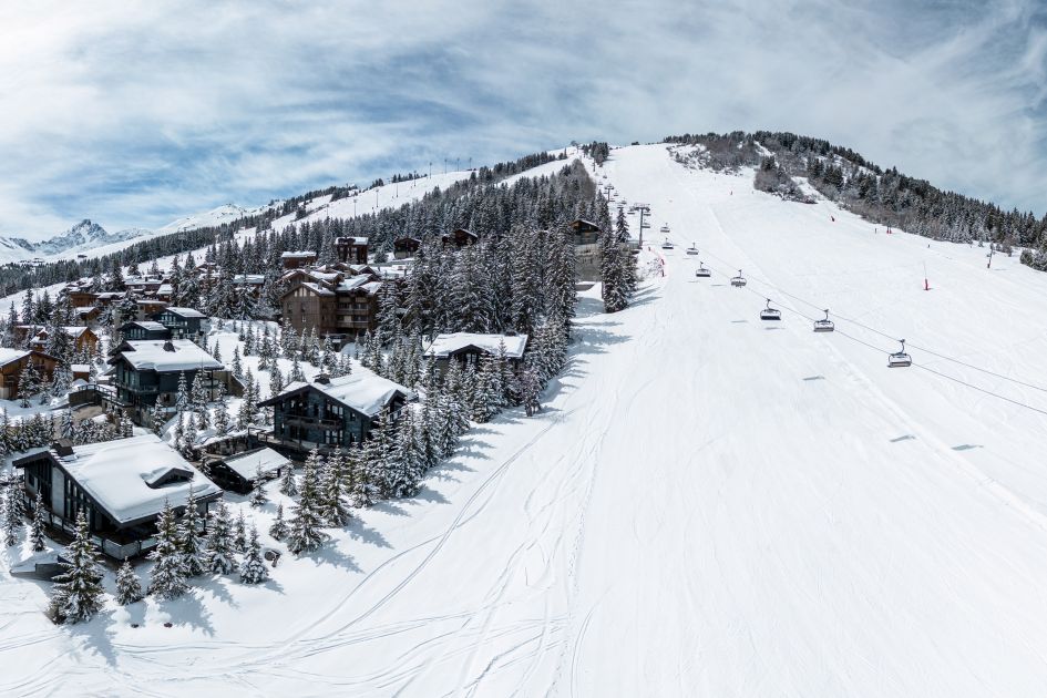 The red Dou du Midi piste, with some of the ski in ski out chalets in Courchevel 1850 visible on the left side of the run.