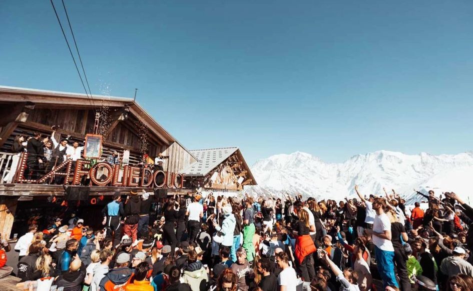 A large group dancing and celebrating at La Folie Douce, a famous mountain bar with access. The perfect place to party before you return to your luxury ski chalet in Saint-Gervais.