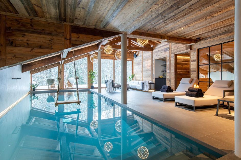 Chalet Tataali's wellness area, complete with a swimming pool, loungers and snowy views outside.