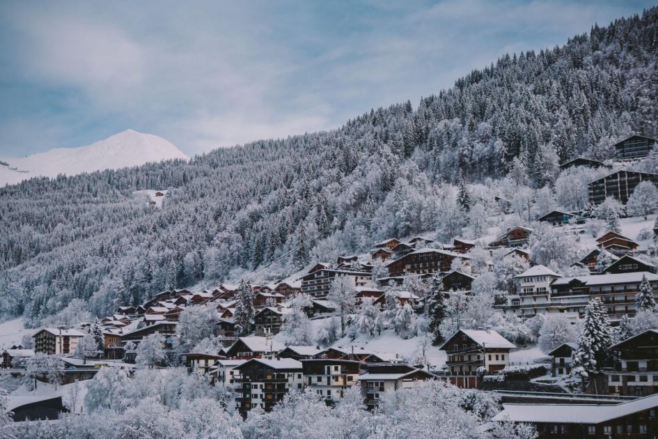 Snow-covered trees and chalets in Morzine ski resort.