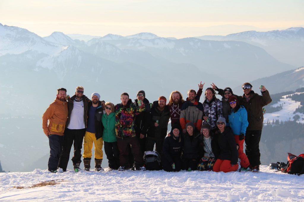 Group of people standing on a mountain posing, all members of Al and Kat's team working in the eco ski chalets in Morzine.