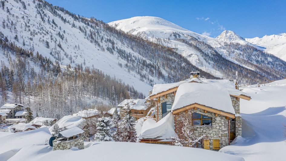 Exterior of Chalet Orca with the snowy mountain views ahead.