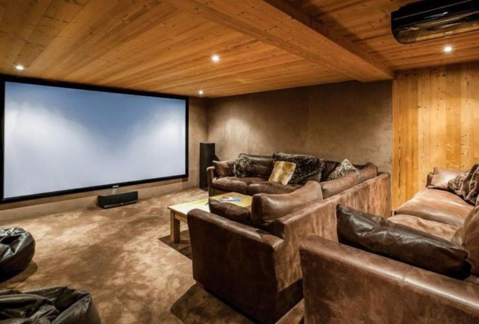 Large theatre room with plenty of comfortable seats, carpet flooring and a wood finished interior, perfect for family movie nights.