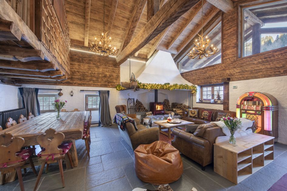 Chalet Doss, Madonna di Campiglio The main living area of Chalet Doss in Madonna di Campiglio, complete with lounge, fireplace, jukebox, and dining table.