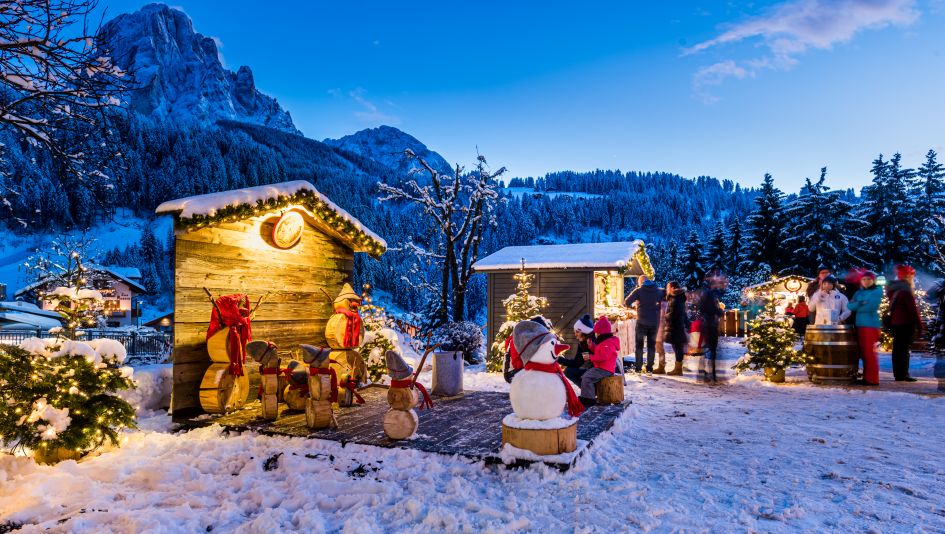 Families together at the Christmas market in Santa Cristina on their ski holiday in the Dolomites Val Gardena. 