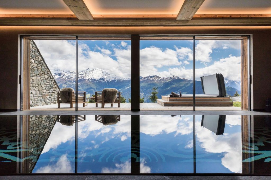 Indoor swimming pool at Calima Estate, with views over the mountains, terrace and outdoor hot tub.