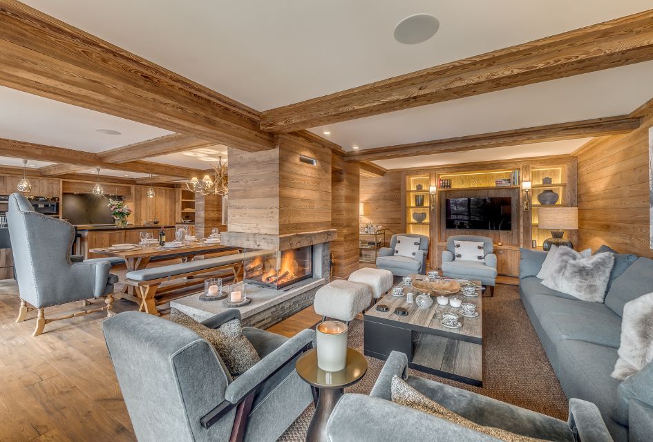 Apartment Petit Chamois, Méribel Grey contemporary furnishing to contrast with the warm blond wood and crisp white paint, a living and dining open-plan living area with a dual aspect wood-burning fireplace in the centre - making it one of the best luxury ski apartments in Méribel