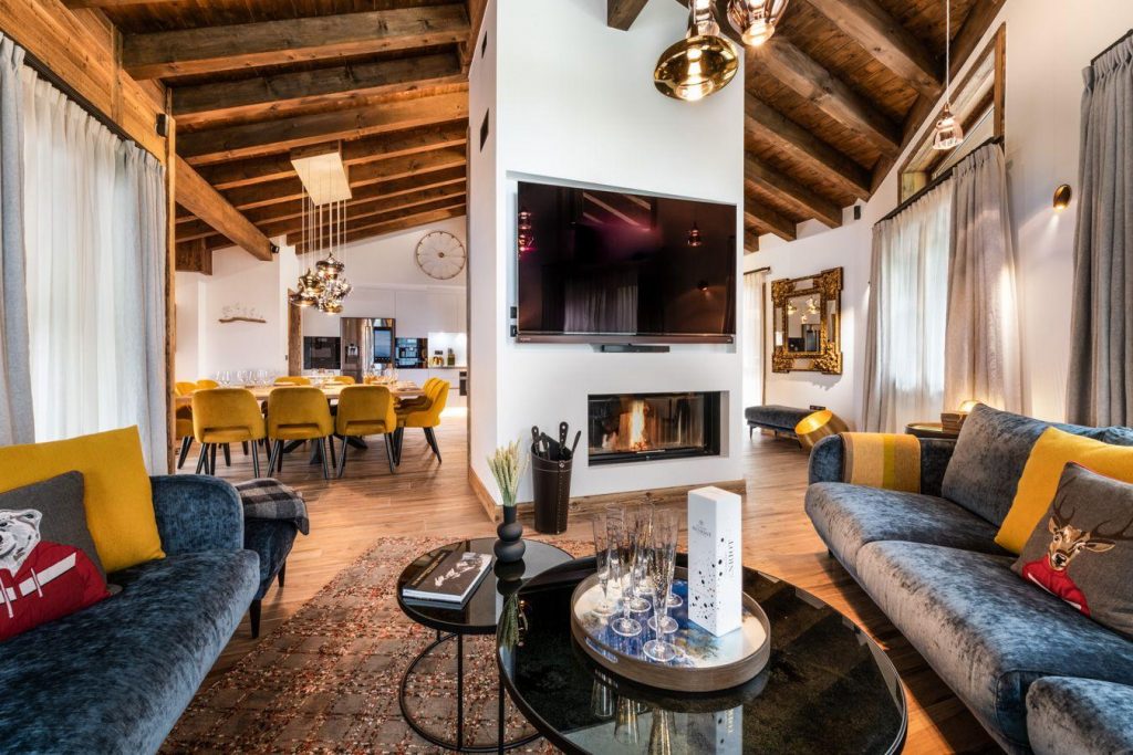 Open plan living room of Kinabalu Penthouse 34 with living area, log fire, dining table and kitchen