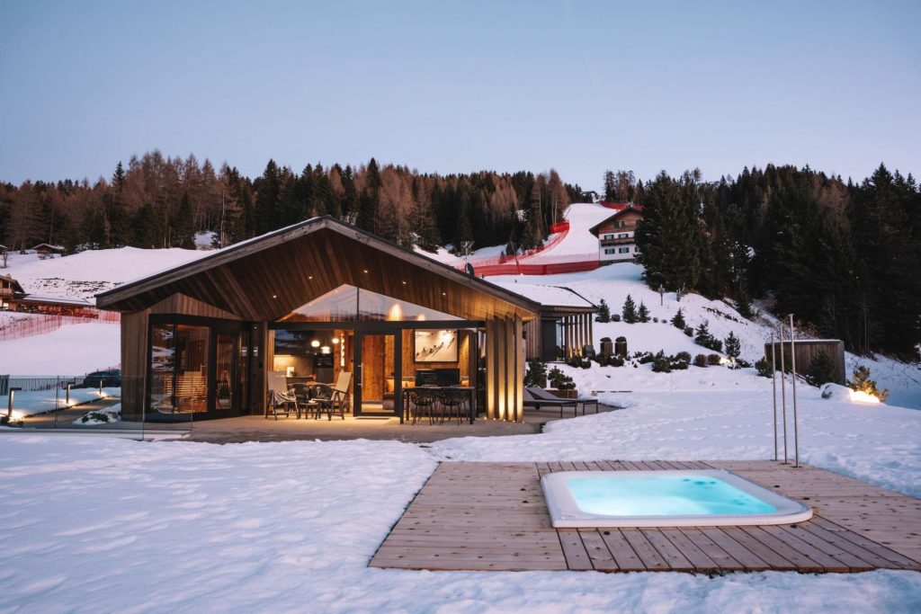 Chalet Ski, Selva Val Gardena Slopeside chalet with a glass facade, offering guests uninterrupted views of the surrounding valley, an outdoor sunken hot tub awaits your return.