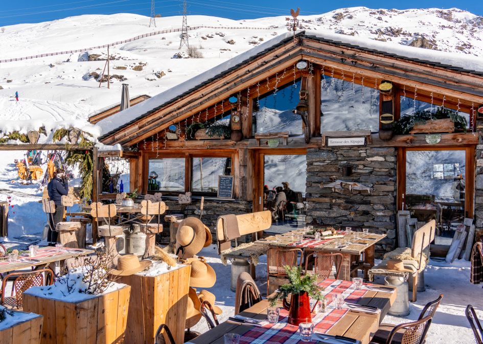 Exterior shot and terrace area of Chez Pépe Nicolas, one of the best mountain restaurants in Val Thorens. 
